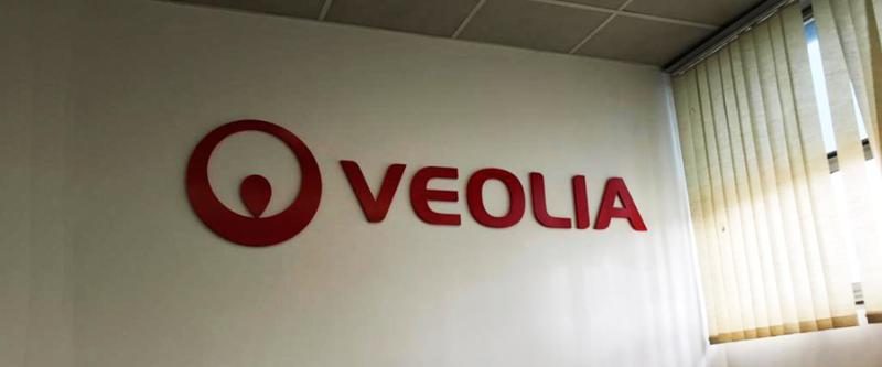 Logo Veolia en lettres relief installé dans un hall d'accueil d'entreprise